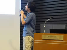 第48回交流研究発表会：大型スクリーンの投影資料を見ながらプレゼンテーションを行うPablo A. Morales氏の様子